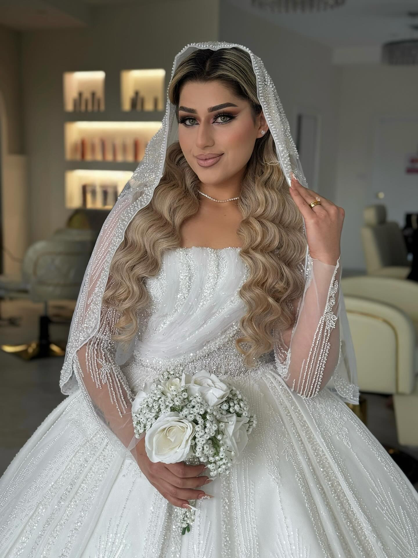 A bride in a white gown and veil, hair in long golden waves